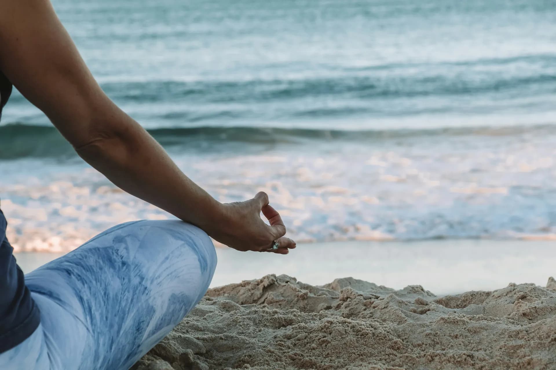 Un hombre meditando en la playa