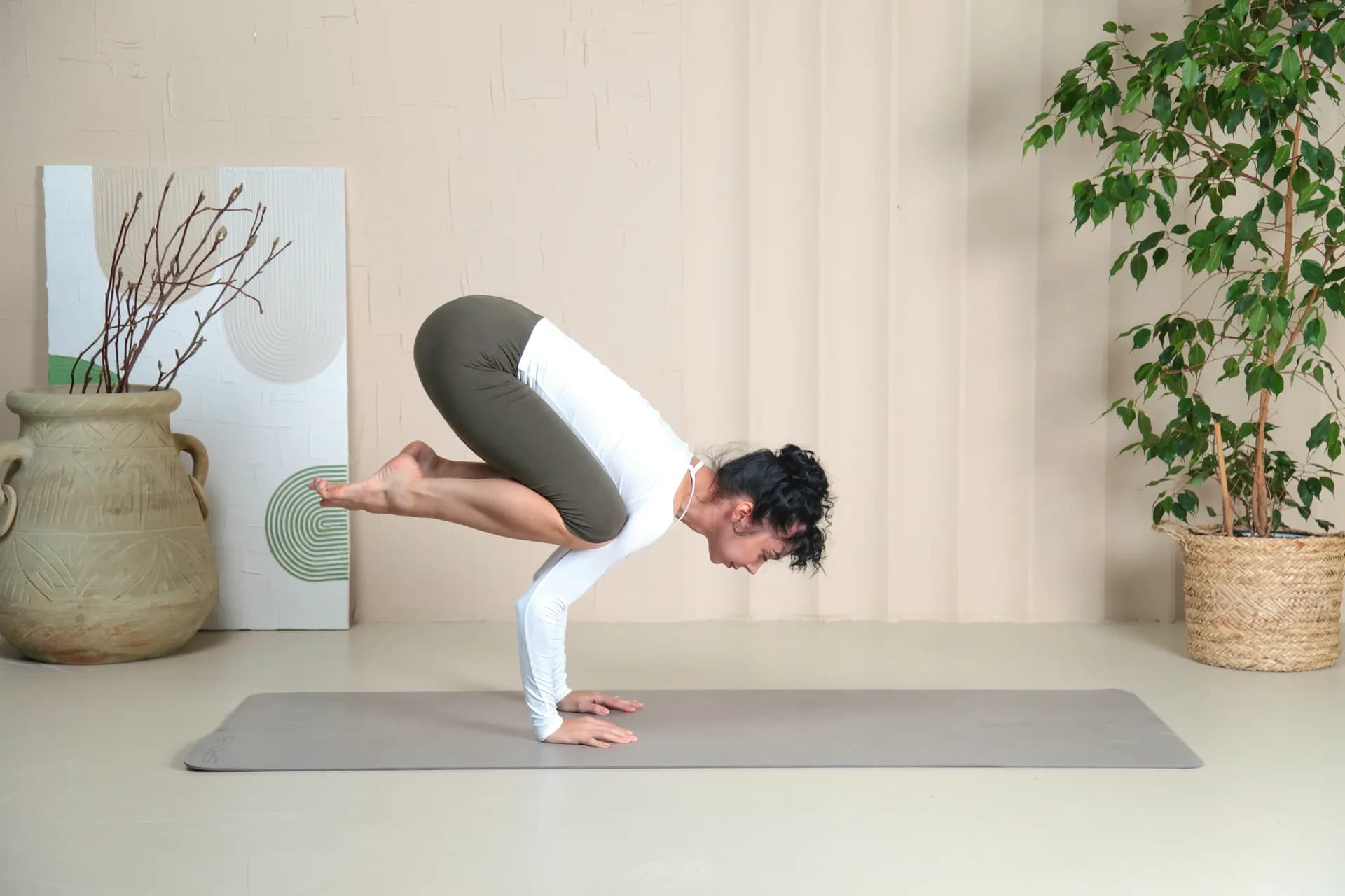 Una mujer está haciendo una postura de yoga en una colchoneta