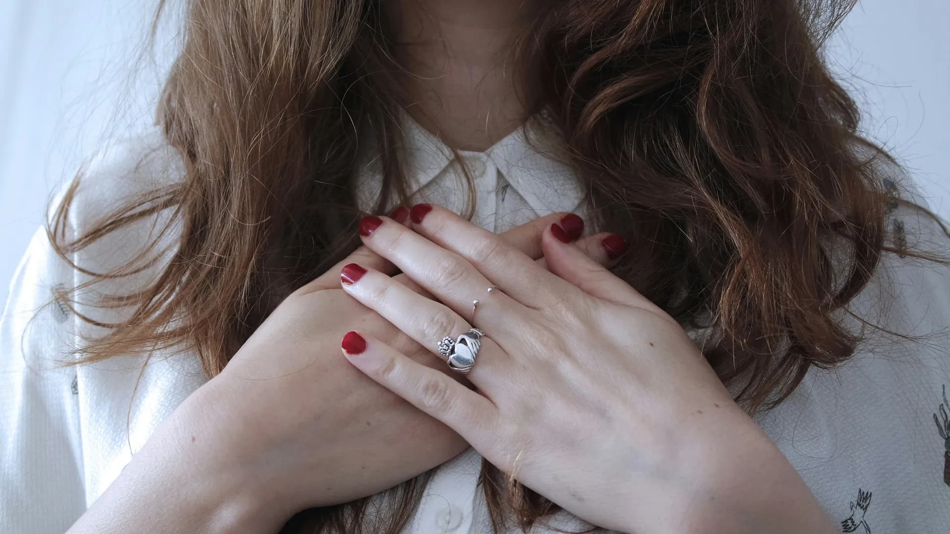 Una mujer colocando sus manos sobre el corazon