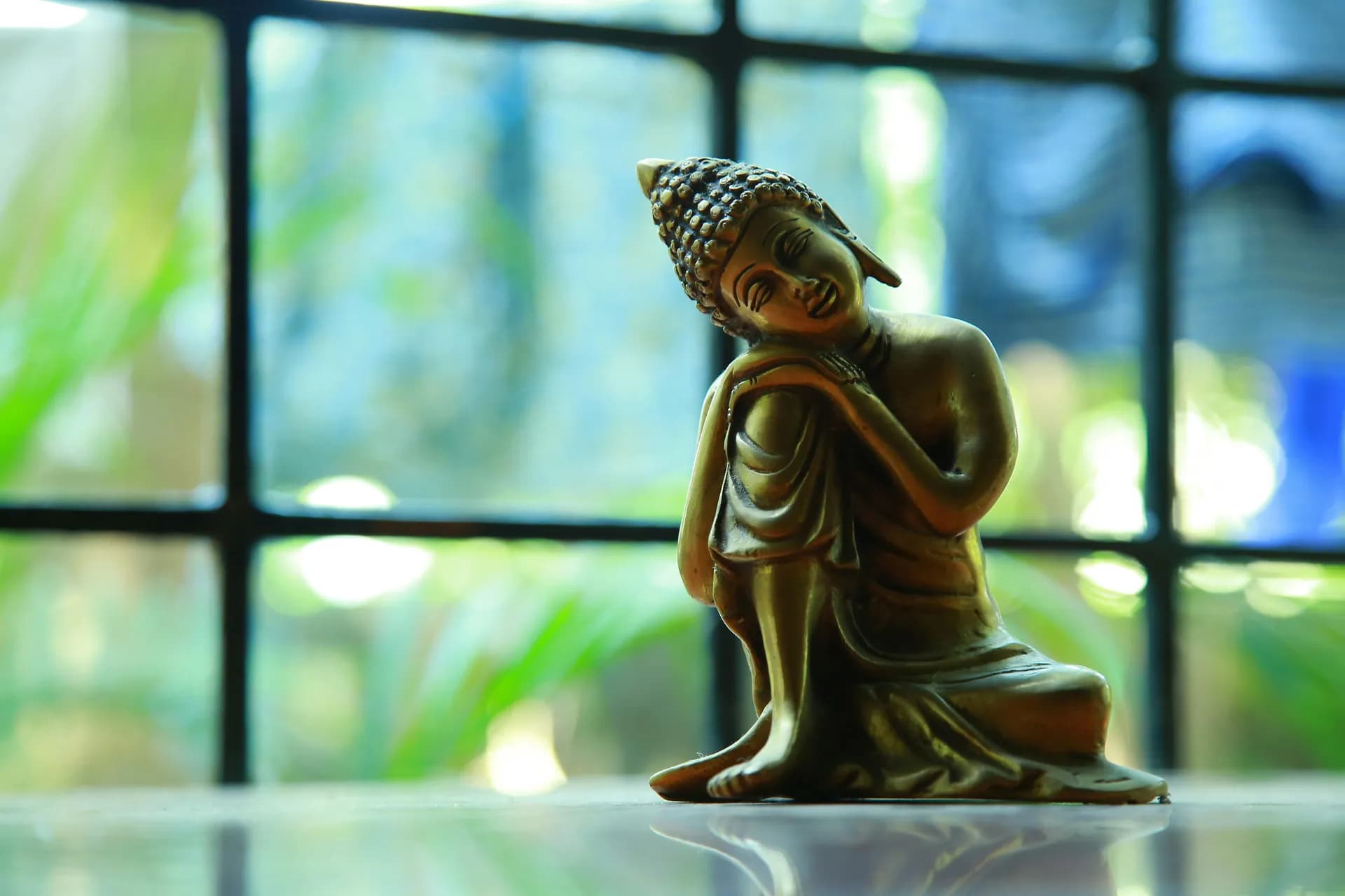 Estatua de buda con la cabeza apoyada en la rodilla