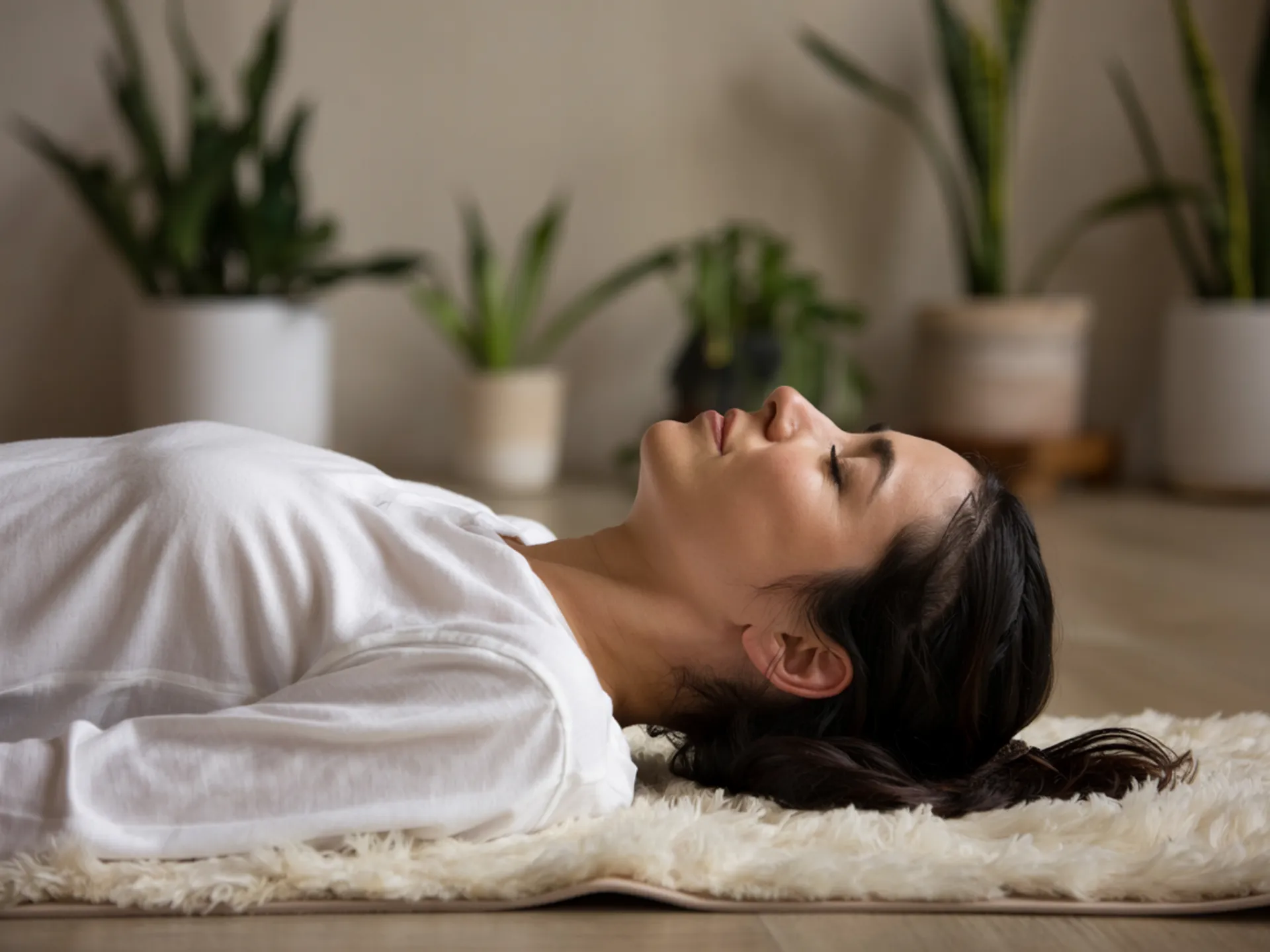 Persona tumbada en el suelo en postura de savasana